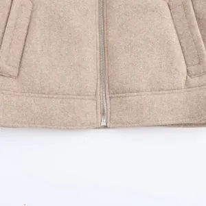 Close-up detail of women's woolen jacket zipper and pocket, soft texture and fine stitching.