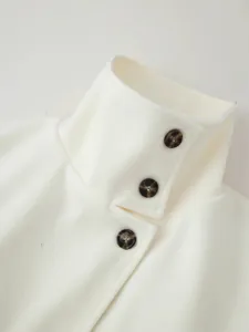 Damen Wollmantel Revers Detail mit einreihigen Schildpattknöpfen in elegantem Weiß.