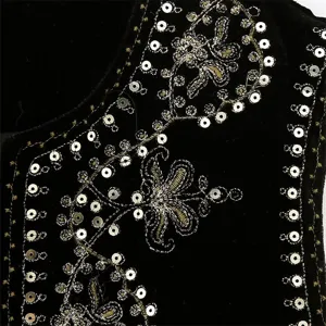 Close-up detail of black velvet vest featuring exquisite sequin and gold embroidery craftsmanship.