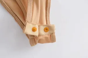 Detailed view of the snap button closure and ribbed fabric texture of a solid color bodysuit.