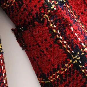 Detailed view of the red plaid tweed blazer fabric, showing textured pattern and pocket design.