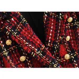 Detailed close-up shot of red tweed double-breasted blazer featuring gold embossed buttons.