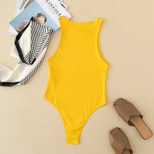Yellow sleeveless bodysuit detail shot, flat lay styling with chic accessories and background.