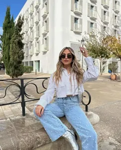 White crop long sleeve button-up shirt with double front pockets, stylish streetwear detail.