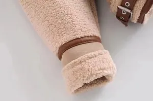 Close up view of fuzzy fleece jacket sleeve with contrast leather trim and metal buckle detail.