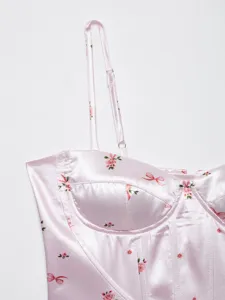 Pink floral satin corset top detail showing adjustable strap and bow print design.
