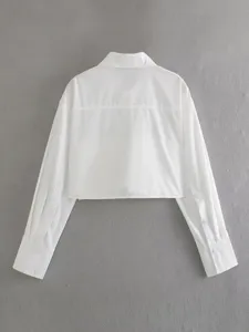 Back view detail of solid white cropped long sleeve shirt with classic collar and yoke seam.
