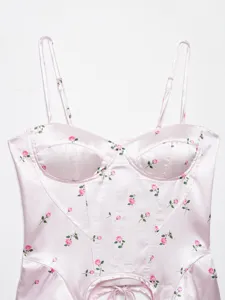 Detailed view of pink floral corset camisole with slim straps and irregular hemline.