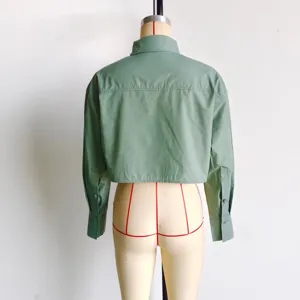 Detailed view of the back of a solid green women's long sleeve crop shirt with shoulder yoke.