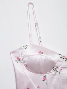 Pink satin corset top detail featuring charming rose floral print, delicate straps and boning.