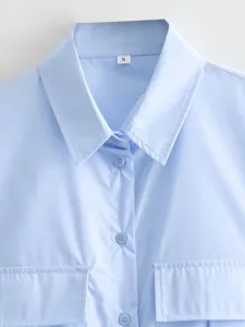 Light blue long sleeve shirt detail, classic lapel collar, front buttons, dual chest pockets.