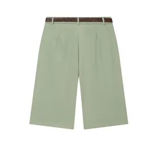 Close-up detail of sage green high-waist pleated shorts featuring a stylish brown crocodile belt.