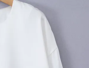 White long sleeve top detail view, showcasing the classic round neck and smooth fabric texture.