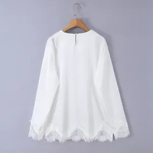 White long sleeve top detail featuring delicate lace hem and back button closure.