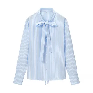 Dettaglio in primo piano dell'elegante camicia a maniche lunghe a righe blu e bianche con fiocco.
