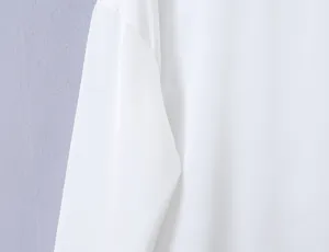Detailed view of solid white long sleeve top fabric and sleeve design, minimalist apparel.