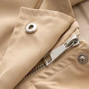 Gros plan des détails de la veste pour femme kaki avec fermeture éclair et bouton pression.