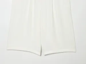 Close-up detail of women's white summer pleated shorts, featuring clean fabric and neat stitching.