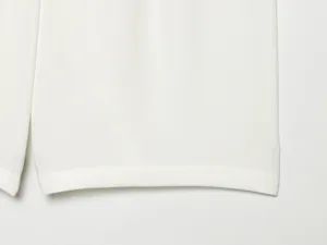 White women shorts hem detail close-up view, premium fabric texture and fine stitching craft.