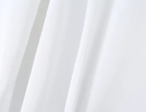 White fabric detail of solid color long sleeve top showing soft texture and smooth drape.