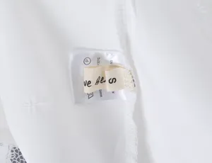 Close-up detail shot showing the inner wash care label and size S tag of the T-shirt.