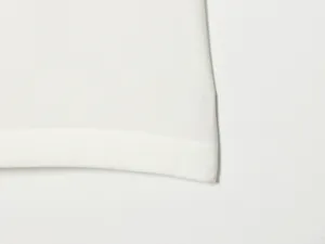 Close-up detail of high-waist women's shorts, featuring clean white fabric and fine stitching.