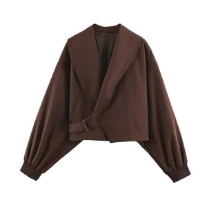 Brown cropped jacket detail showcasing wide lapel, asymmetric buckle belt and balloon sleeves.