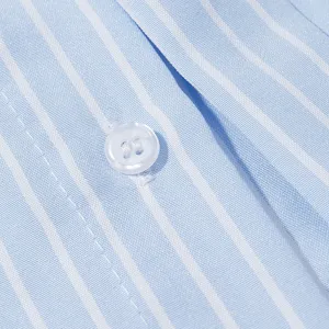 Primo piano dettagliato del tessuto di camicia a righe azzurre e bianche con bottone.