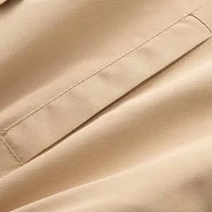 Gros plan détaillé du tissu sergé kaki de qualité et des coutures de poche femme.