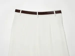 Detailed view of women's white high-waisted pleated shorts featuring a stylish brown belt.