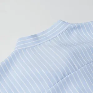 Primo piano del colletto della camicia a righe blu e bianche con dettagli di cucitura.
