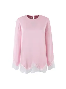 Pink long sleeve top featuring a round neckline and delicate white lace trim at cuffs.