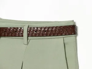 Green shorts waist detail with brown textured belt, high waist design and pleated front style.