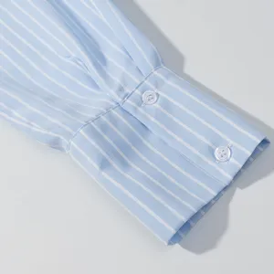 Primo piano dettagliato del polsino della camicia a righe blu e bianche con bottoni.