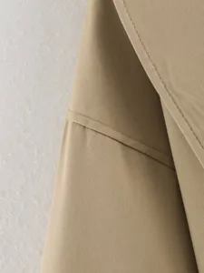 Khaki trench coat fabric detail featuring classic lapel stitching and premium texture for women.
