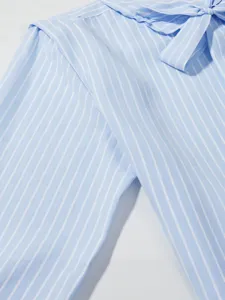 Camicetta a righe azzurre con fiocco, elegante moda femminile francese autunnale chic.