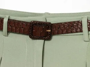 Close-up detail of womens high waist pleated shorts featuring brown snakeskin belt.