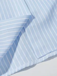 Dettaglio del tessuto della camicia a righe azzurre e bianche, elegante top francese.