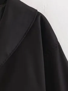 Close-up detail of the black short coat featuring a large lapel and neat shoulder stitching.