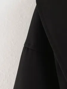 Close-up detail of black women's short coat lapel and stitching, premium fabric texture view.