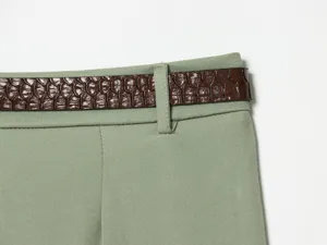 Close up view of women high waist shorts waistband detail with stylish brown embossed belt accessory.