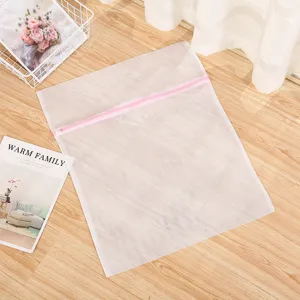 Vue detaillee du sac a linge en filet blanc avec fermeture eclair rose pour protection.