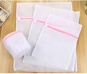 Lot de sacs de lavage blancs avec fermetures éclair roses pour lingerie et vêtements délicats.