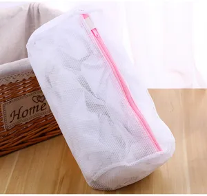 Sac à linge cylindrique blanc avec fermeture éclair rose, vue détaillée de la structure en fine maille.