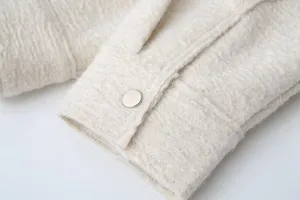 Close up detail of women casual beige tweed jacket sleeve with metal snap button.