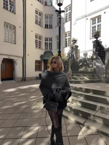 Women asymmetrical short scarf knit cape coat worn outdoors, stylish autumn winter outerwear.