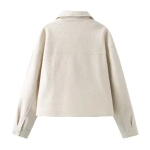 Back detail view of beige tweed lapel short jacket, showcasing clean seams and button cuffs.