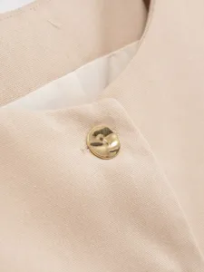 Beige sleeveless vest button detail, elegant commuting style summer new fashion apparel close-up.