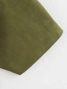 Olive green velvet fabric detail close-up showing soft texture and fine material quality.