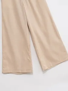 Detail view of women's wide-leg trousers, showcasing fine fabric texture and neat tailoring.